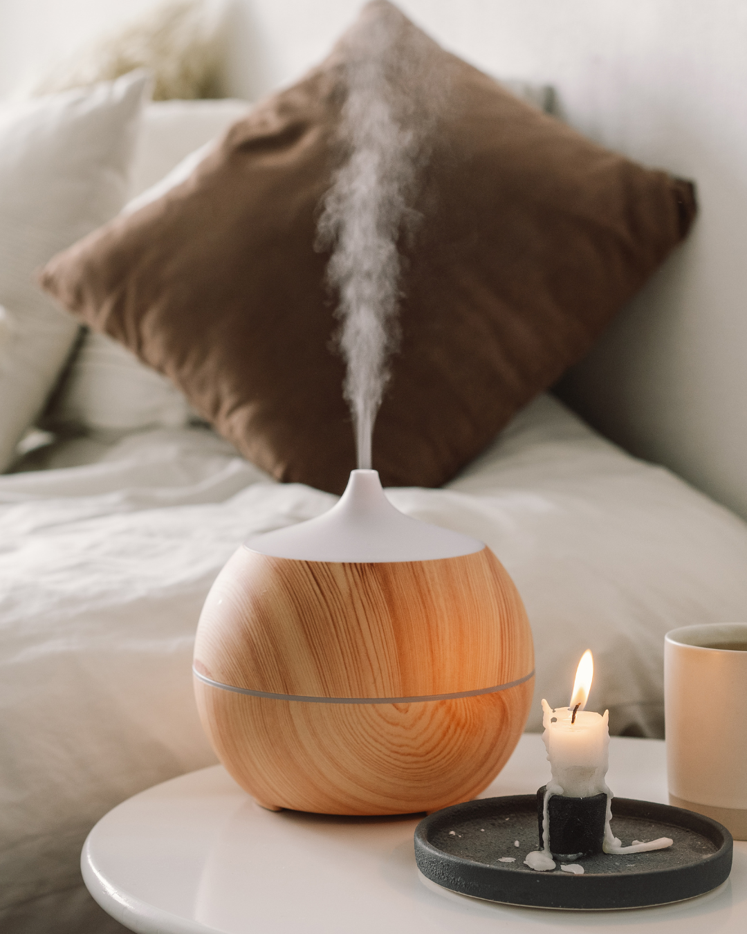 Flat lay of Plant Therapy essential oils for stress relief, including Clary Sage, Bergamot, Lavender, and Roman Chamomile, arranged on a beige background with eucalyptus leaves and bold navy text reading 'The Best Essential Oils for Stress Relief